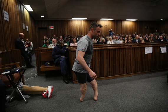 Paralympic gold medalist Oscar Pistorius prepares to walk across the courtroom without his prosthetic legs during the third day of his hearing at the Pretoria High Court for sentencing procedures in his murder trial in Pretoria on June 15, 2016. A sobbing Oscar Pistorius walked hesitantly on his stumps around court on June 15 in a dramatic demonstration of his disability ahead of his sentencing for murdering his girlfriend Reeva Steenkamp. / AFP PHOTO / POOL AND AFP PHOTO / SIPHIWE SIBEKO